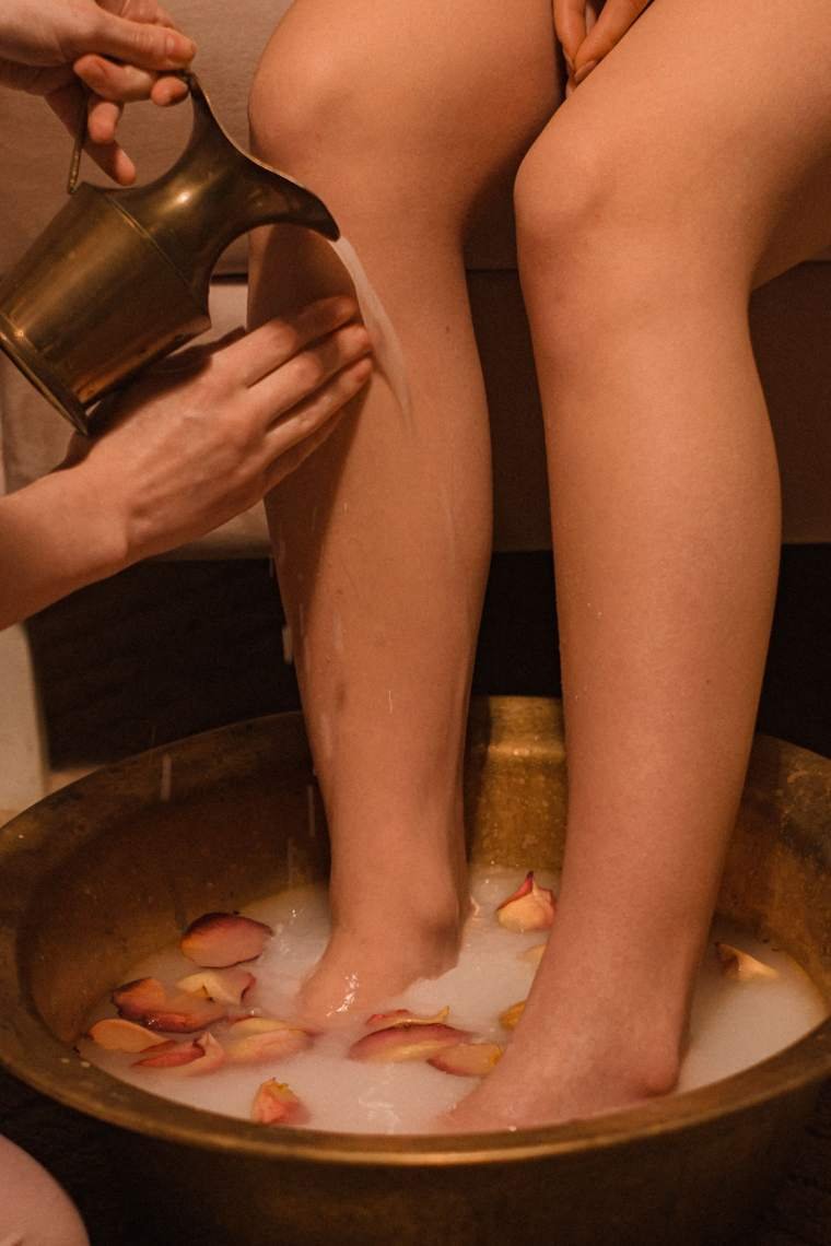 Foot ritual in a brass bowl with rose petals and milk